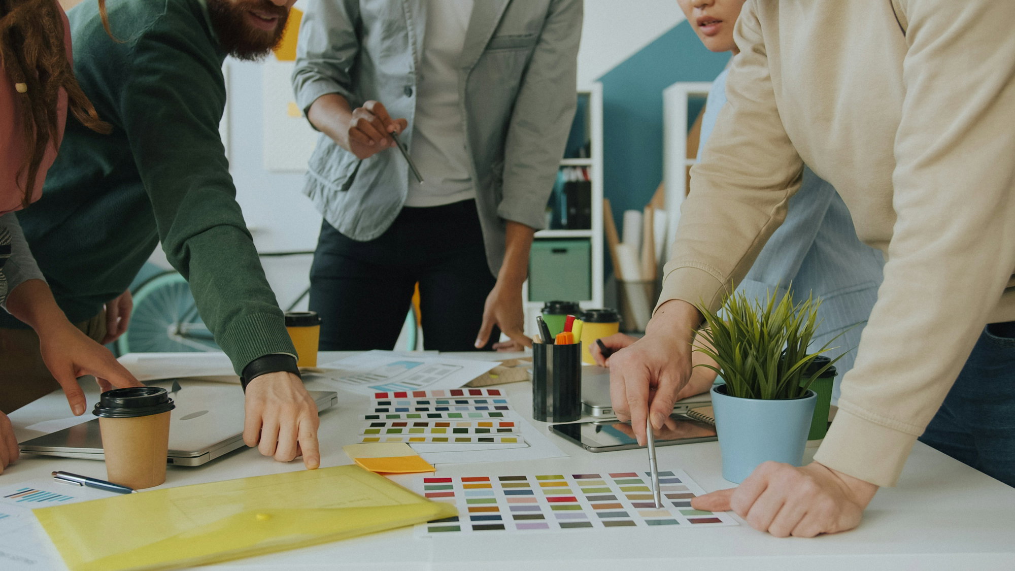A group of people collaborating on a design project at a white table